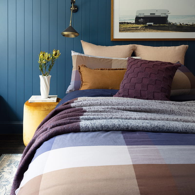 Side details shot of the quilt cover set features a large check design in purple, navy, and beige tones. Made of high-quality, yarn-dyed cotton fabric, it adds sophistication to any bedroom.