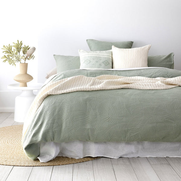 alt="A soft green tones quilt cover set featuring a subtle textural leaf pattern offers a calming bedroom look"