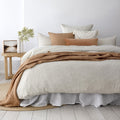 alt="A beautiful neutral stone colour quilt cover set featuring a geometric pattern in a bohemian-theme bedroom"