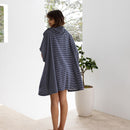 A woman standing representing a versatile adult poncho ideal for travel and relaxation.