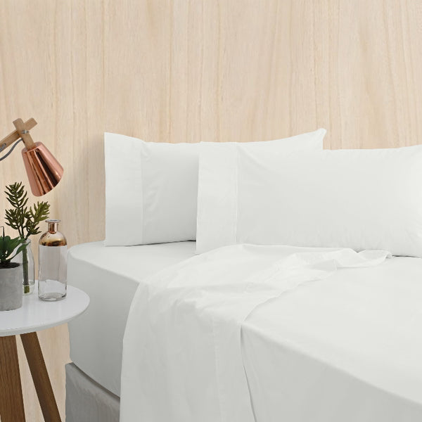 alt="A white bamboo cotton sheet set featuring its minimal, inviting softness and comfort in a cosy bedroom set-up" 