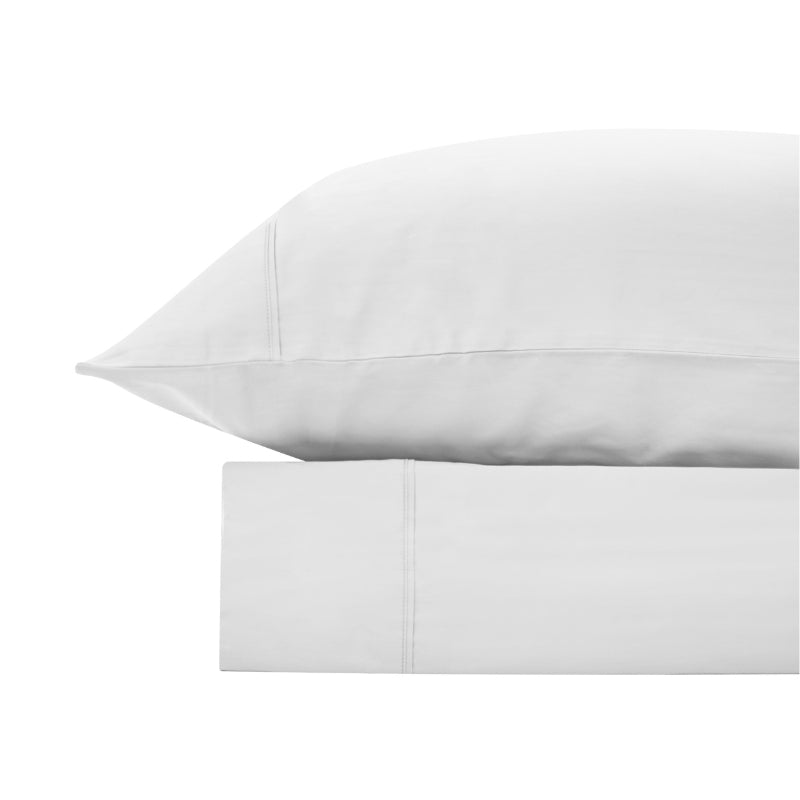 alt="A white bamboo cotton sheet set featuring its minimal, inviting softness and comfort"