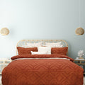 alt="Luxurious quilt cover set in an orange hue features a captivating geometric design matching with the pillowcases"