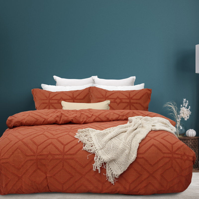alt="Luxurious quilt cover set in an orange hue features a captivating geometric design matching with the throw and pillowcases"