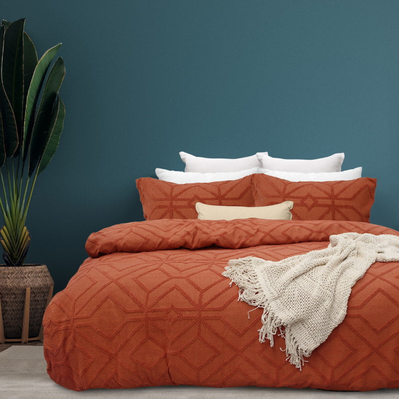 alt="Luxurious quilt cover set in an orange hue features a captivating geometric design matching with the throw and pillowcases"