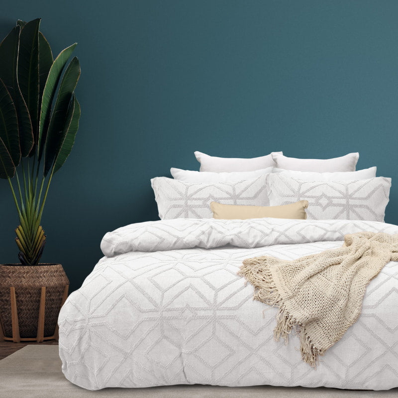 alt="Luxurious quilt cover set in a white hue features a captivating geometric design matching with the throw and pillowcases"
