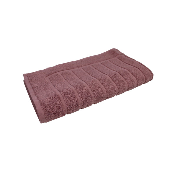 alt="The dusty rose Zero Twist bath mat unveils intricate folded details, adding a luxurious touch to your bathroom"