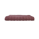 alt="The dusty rose Zero Twist bath mat unveils intricate folded details, adding a luxurious touch to your bathroom"