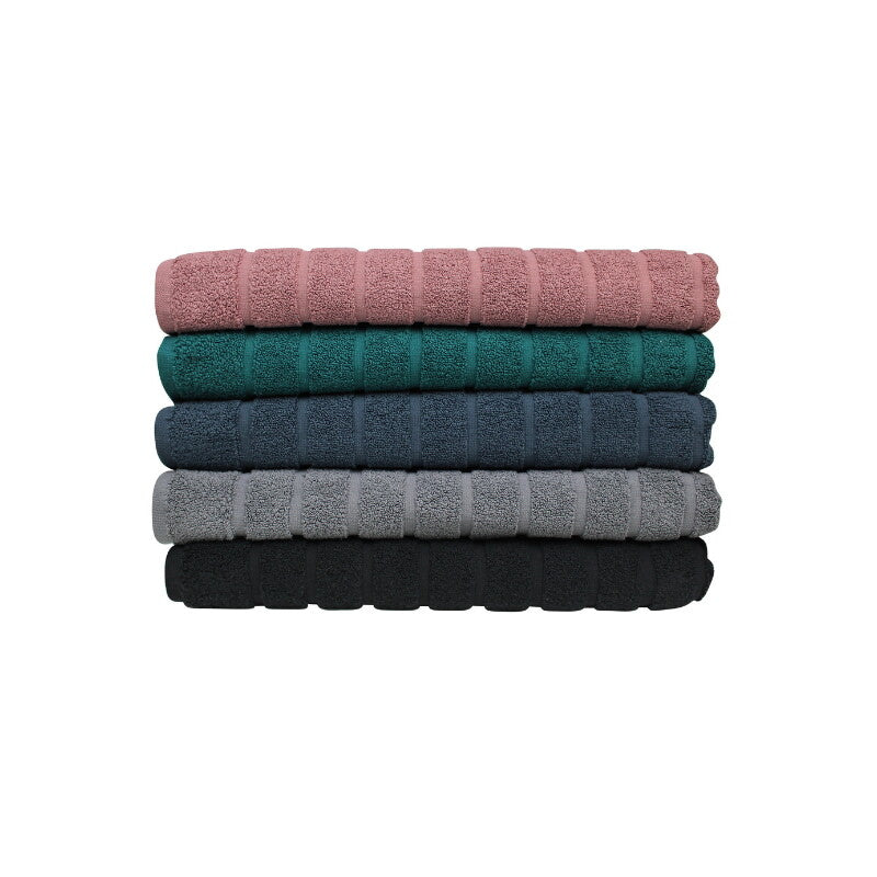 alt="A pile of folded Zero Twist bath mats showcasing their stylish and comfortable elegance."