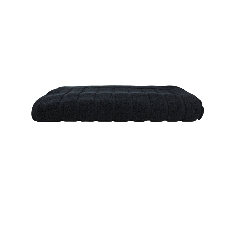 alt="The black Valencia Zero Twist bath mat unveils intricate folded details, adding a luxurious touch to your bathroom"