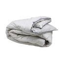 alt="Side angle view of the folded quilt crafted washable wool for decadently cosy warmth"