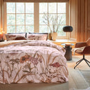 Cosy quilt cover set with soft peach tones and wildflower print against a large window backdrop