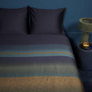 Top view of Lenny Blue quilt cover styled in a navy-toned room with matching decor