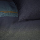 Close-up of Lenny Blue quilt cover showing gradient dotted pattern in blue and ochre