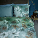 Side view of the Lou Blue Green Quilt Cover styled with neutral-toned accessories and ceramic decor items