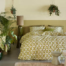Bedding House Mae Seersucker Green Quilt Cover styled in a leafy bedroom with soft layered pillows