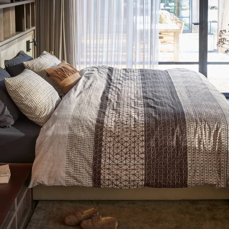 Bedding House Mathis Natural Quilt Cover Set on a made bed with sunlit sheer curtains behind