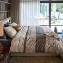 Bedroom featuring the Mathis quilt cover styled with earthy decor and warm lighting
