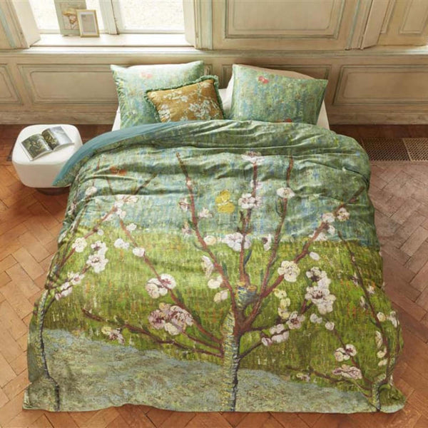 alt="Quilt cover inspired by Vincent van Gogh's 'Blossoming Peach Tree' painting in a cosy bedroom."