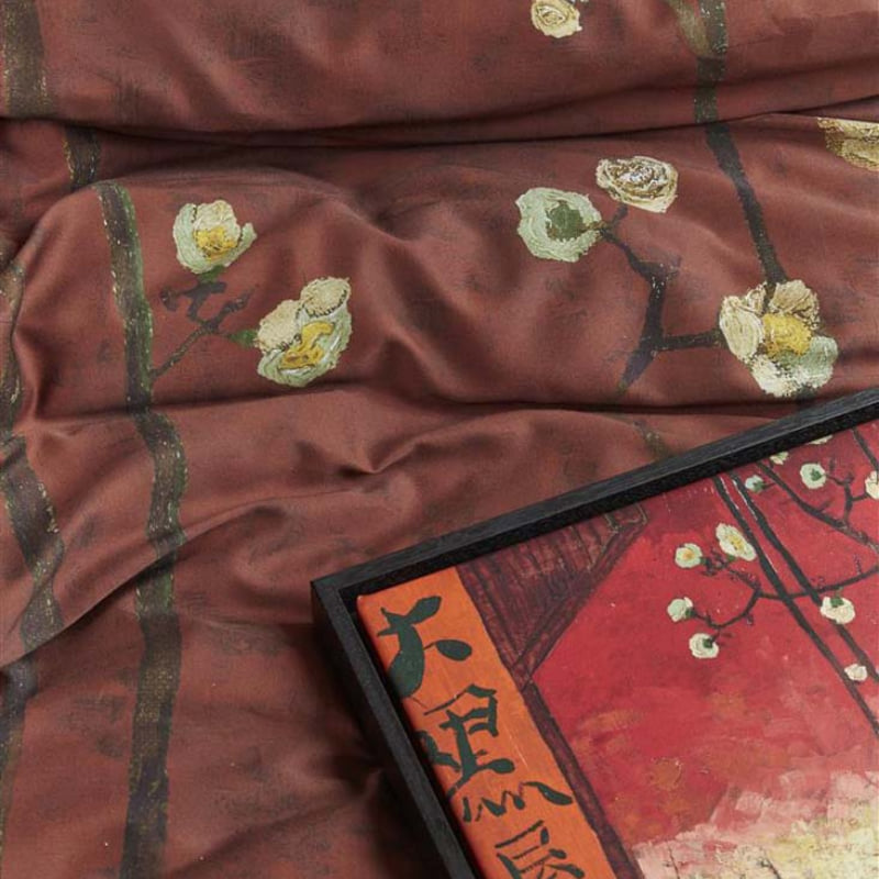 alt="Close up look of a Japanese-inspired quilt cover with a vibrant flowering plum orchard pattern on a deep red background."