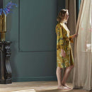 alt="A woman wearking Van Gogh-inspired Almond Blossoms kimono with gold background"