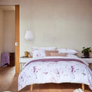 A tranquil bedroom scene featuring a purple floral bedding, enhancing the room's charm and relaxation.
