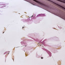 Close up details of the print of a purple floral bedding, enhancing the room's charm and relaxation.