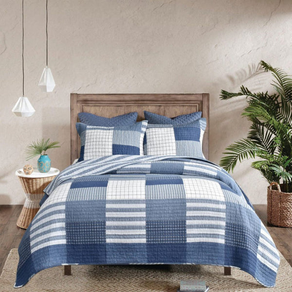 Blue and white quilt with checkered pattern coverlet set, featuring patchwork design with grid-like quilting for a textured and geometric appearance.