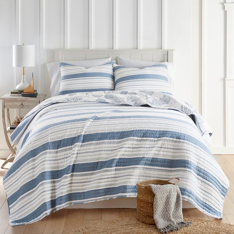 Reversible throw featuring coral and seashell backing for coastal style.