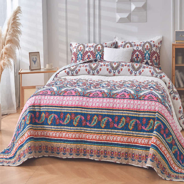 A colourful patterned coverlet set featuring vibrant pink, blue, and yellow hues against a white background, boasting a bohemian style with intricate geometric and floral motifs.