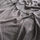 alt="Close-up details of a luxurious grey throw blend of acrylic and wool, featuring a vibrant design and stylish tassel accents"