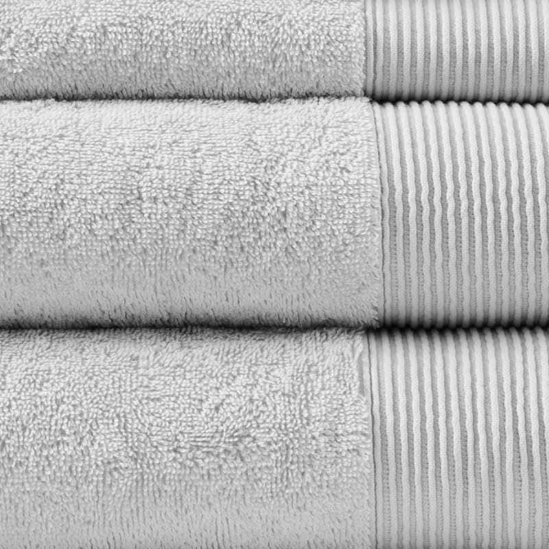 Detailed shot of a stack of luxurious grey towels made from eco-friendly Tencel and cotton, promoting sustainability and advanced hygiene.