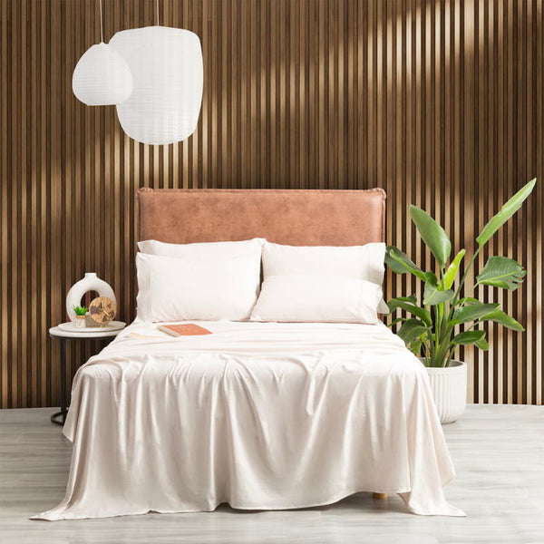 Luxurious bed with crisp sand sheet sets and plump pillows, elegantly placed against a tastefully adorned wall.