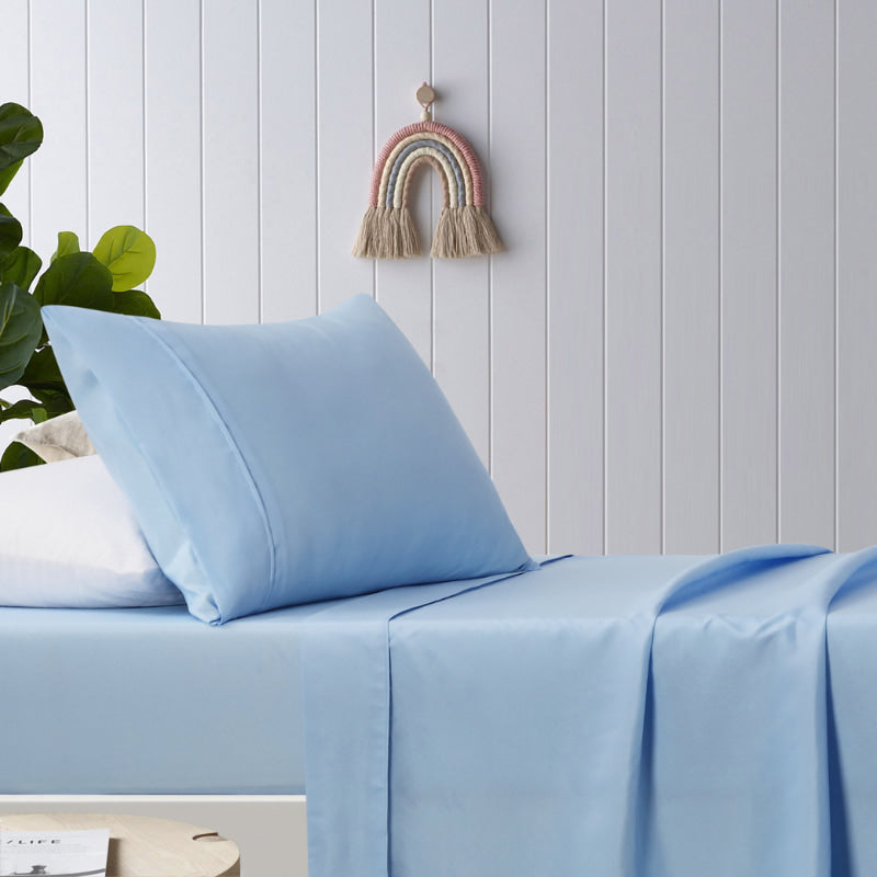 alt="A blue, plain dyed microfibre sheet set in a cosy bedroom"
