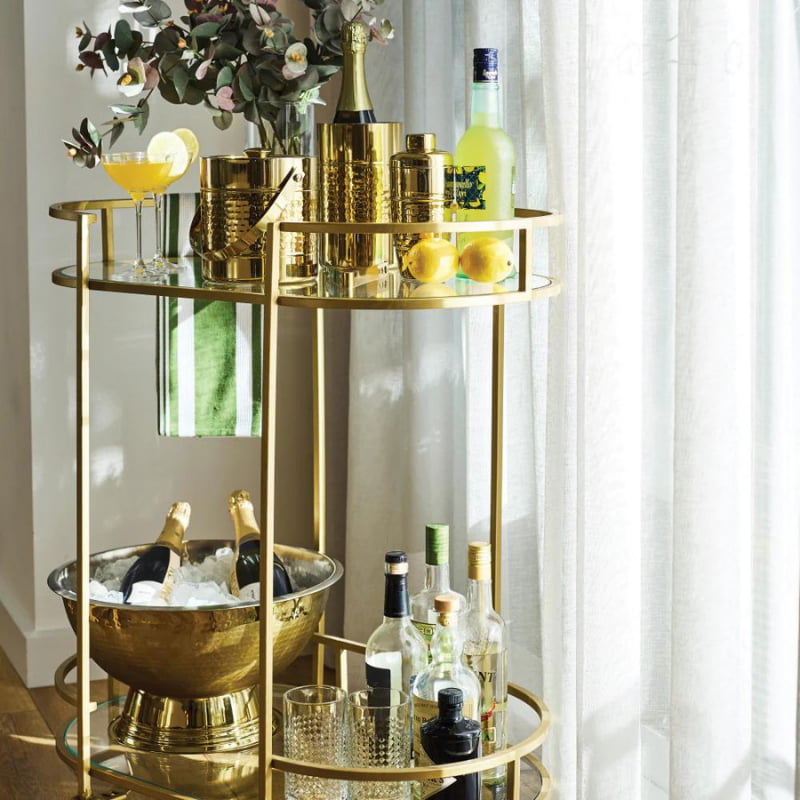 alt="A stunning hammered gold wine cooler surrounded by other collections featuring its high quality."