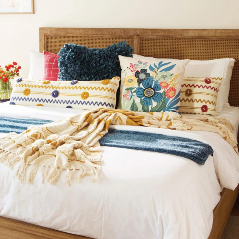 alt="Our beautiful crafted cushion set-up in a bed."
