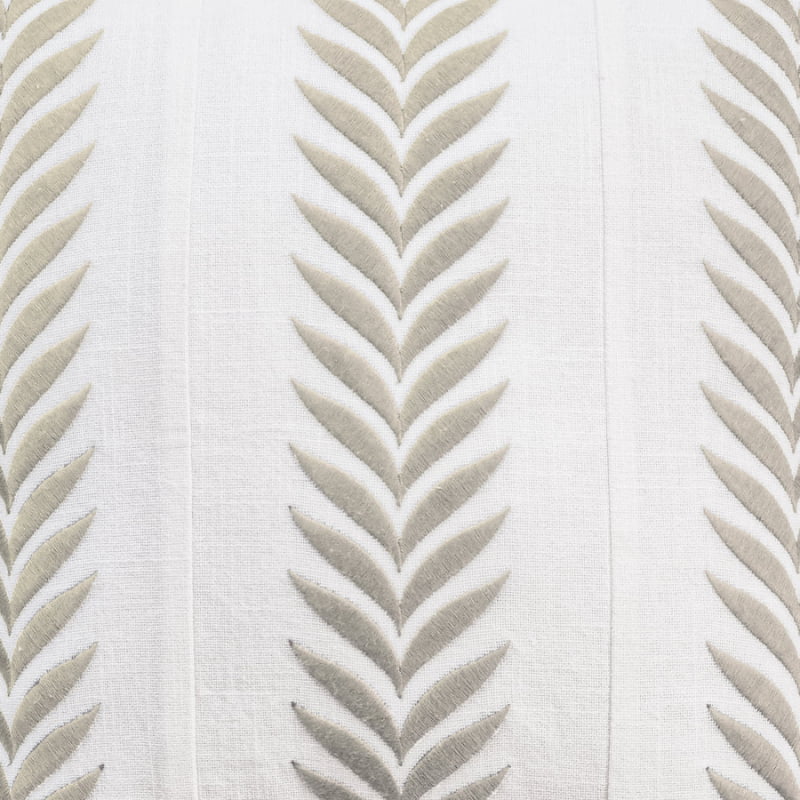 alt="Close up details of a coastal inspired grey and ivory cushion featuring an embroidered geometric leaf design with piped edging"