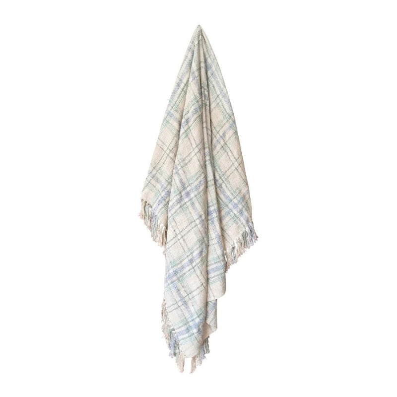 alt="A green multicoloured throw  features a playful check pattern weaved from different coloured string, with tassels on each side"