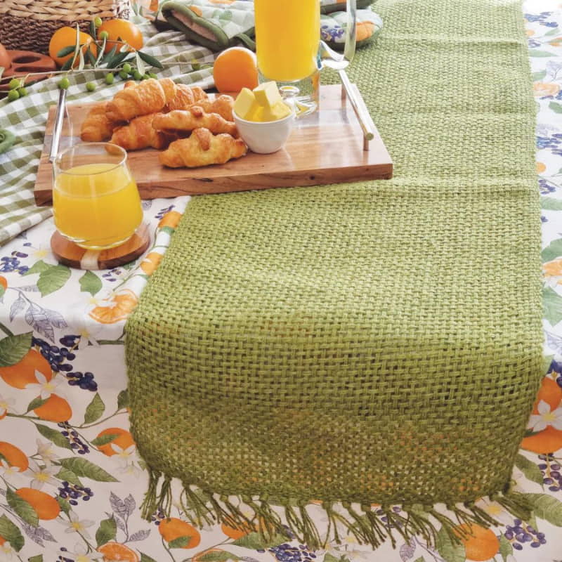 alt="Close-up look of a unique eco-friendly jute green runner with playful fringe in a stunning setup table."
