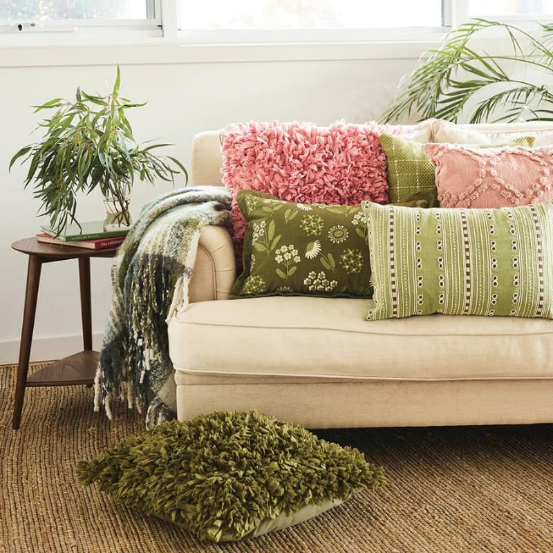 "A green and cream check pattern cushion pairs with other collections of chic companion pillows."