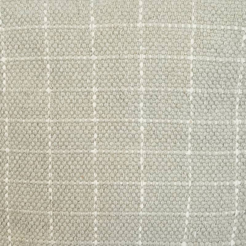 alt="Close-up details of a grey beige cushion featuring a cream check pattern"