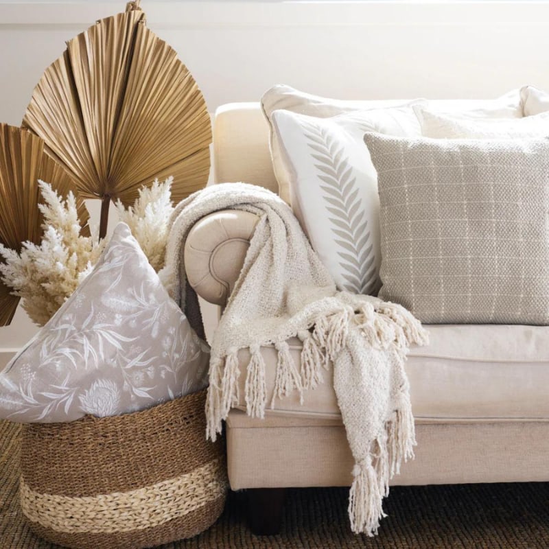 "A grey beige and cream check pattern cushion pairs with other collections of chic companion cushions in a stunning bohemian-inspired living space."