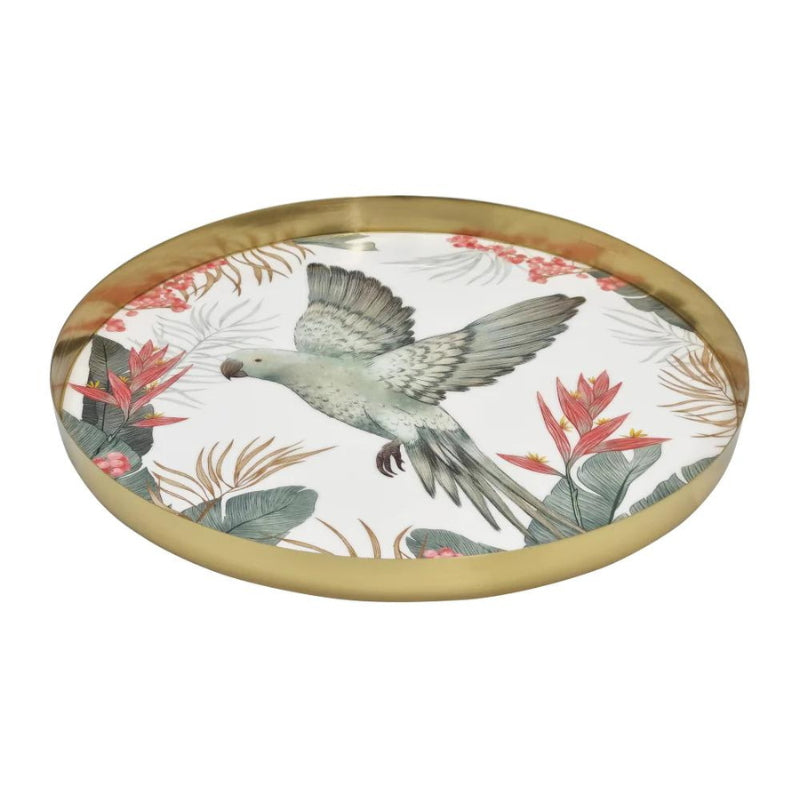 alt="A round serving tray with a tropical design featuring a flying bird amidst lush foliage laid down"
