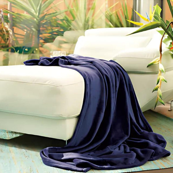 A navy throw elegantly draped over a white couch, enhancing the cosy atmosphere of the living space.