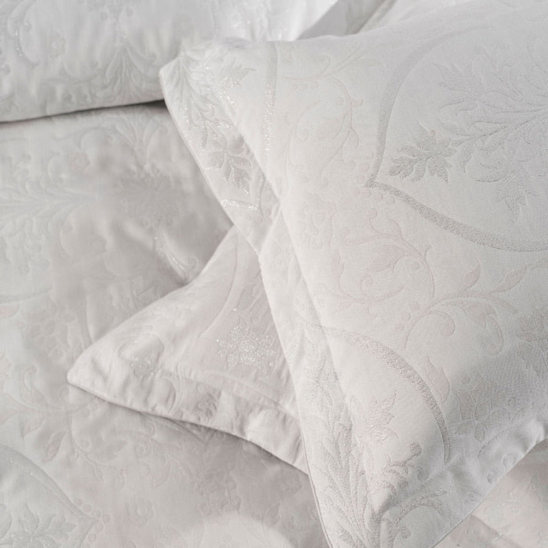 alt="Closer shot of shimmering jacquard quilt cover set in a bedroom"
