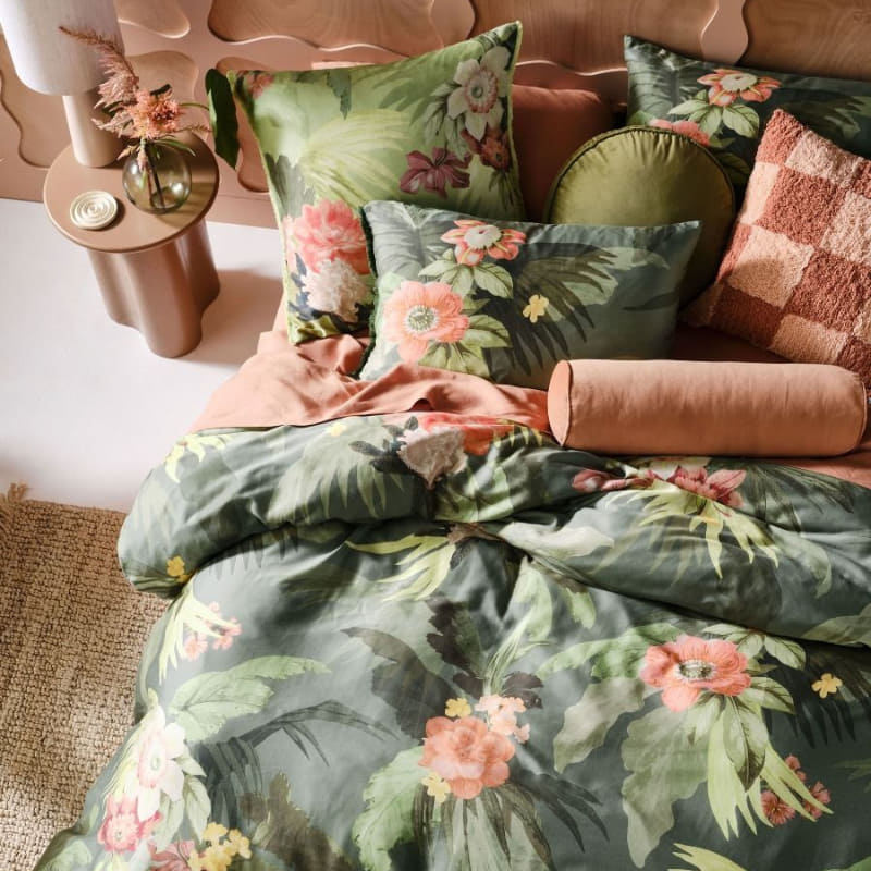 alt="A cotton quilt cover set outlined an archival tropical print ensemble with its coordinating European pillowcases and cushion  in a cosy bedroom"
