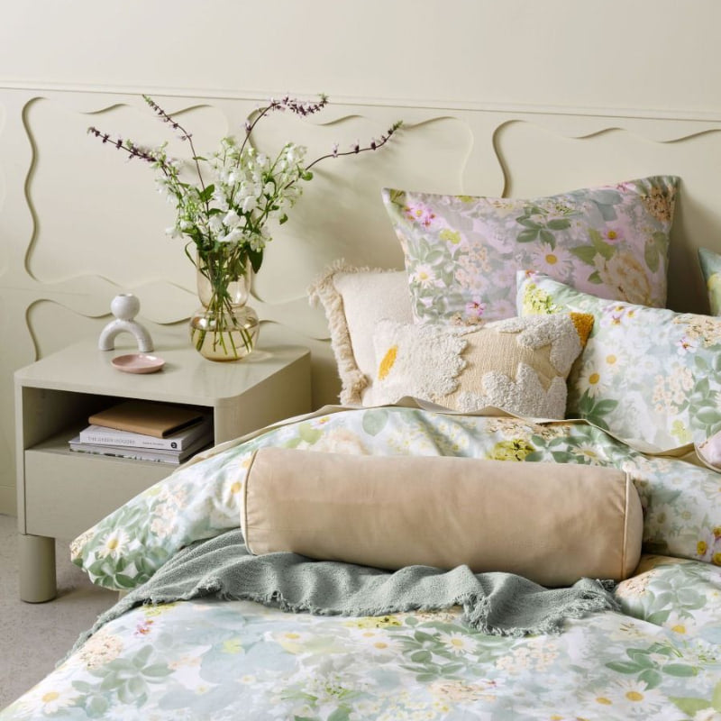 "A photographic floral motif quilt cover set paired with European pillowcases and tufted cushion  in a comfy bedroom"