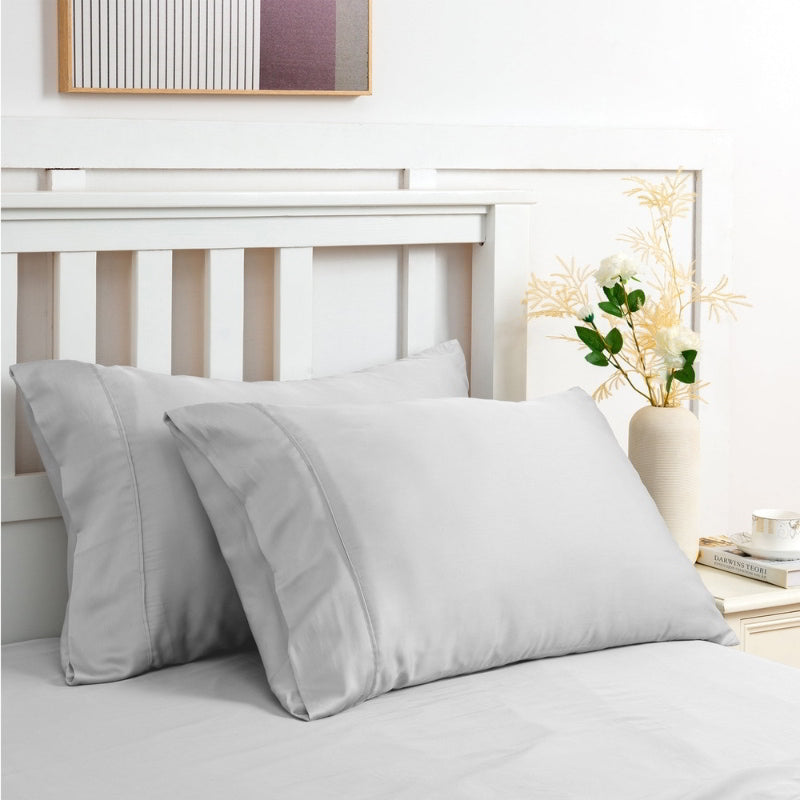 alt="Light grey sheet set along with the pillows produce a lustrous silky smooth fabric to your bedroom"