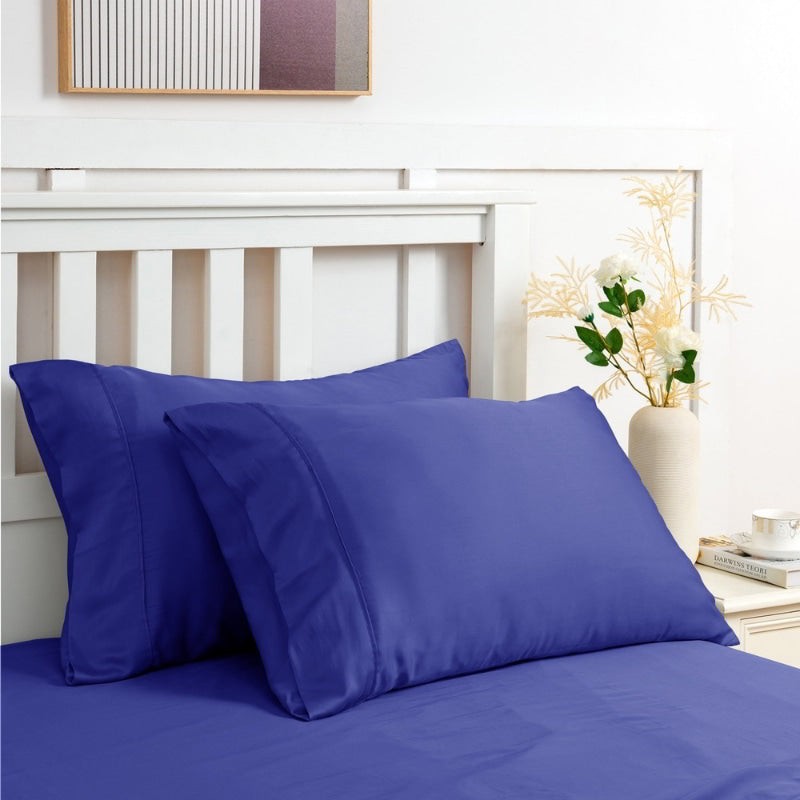 alt="Navy sheet set along with the pillows produce a lustrous silky smooth fabric to your bedroom"