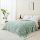 A cosy bed featuring a green blanket, perfect for a stylish and inviting bedroom atmosphere.